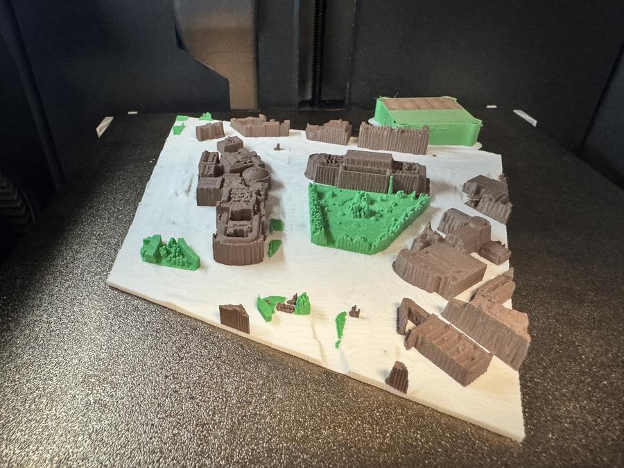 A photo of a large multicolour 3D print of an area of central Liverpool. The ground is white, buildings are brown and parks/grass areas are green.