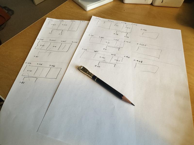 A photo showing various aligned boxes scribbled in pencil on two sheets of paper.