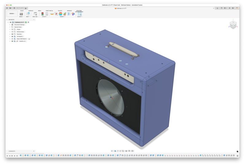 A screenshot of a CAD tool showing a a guitar amplified being designed. The case is a blue box, there is a black panel with a speaker mounted in it, a handle on top, and a panel with holes in it for various controls.